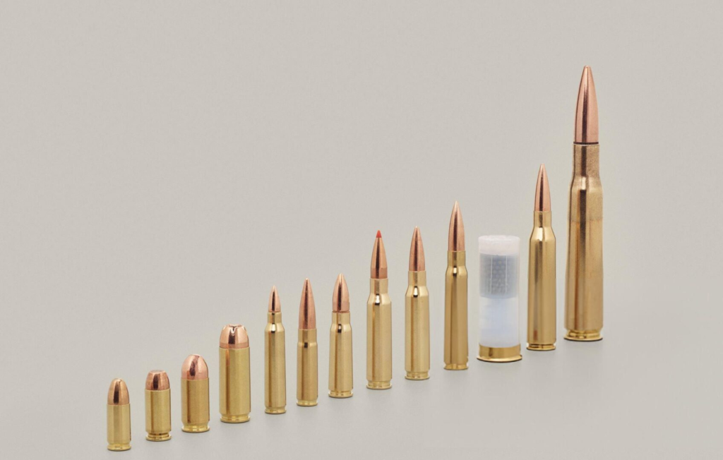 Variety of bullet cartridges on beige background - stock photo