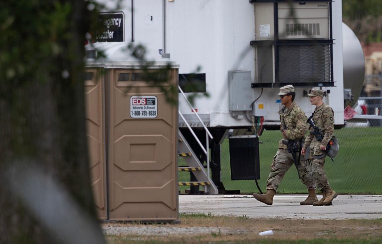 Photo of National Guard members arriving at a military post or training center.
