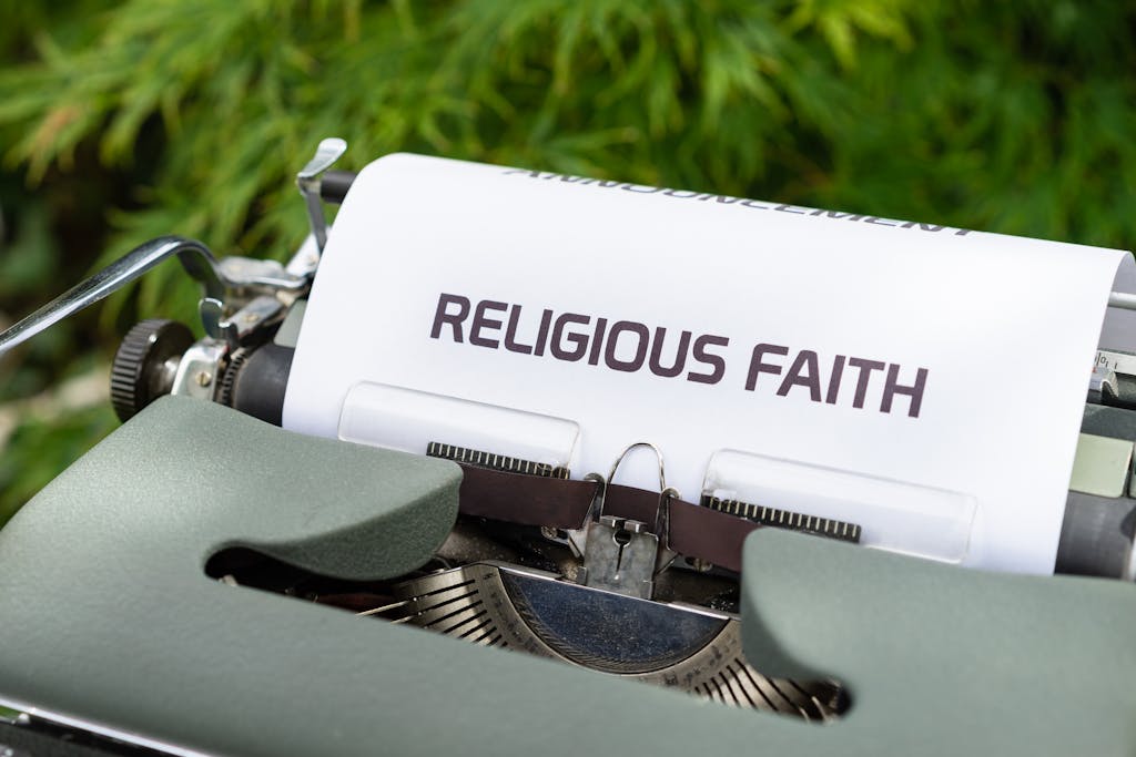 Close-up of a vintage typewriter typing 'Religious Faith' on paper outdoors.
